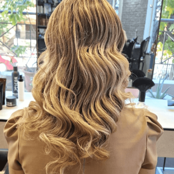 Professional hairstyling on a client's hair, creating a stylish and trendy hairstyle in a modern salon. - center